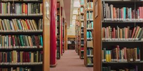 A photo of an aisle between bookshelves in the Tyndale House library